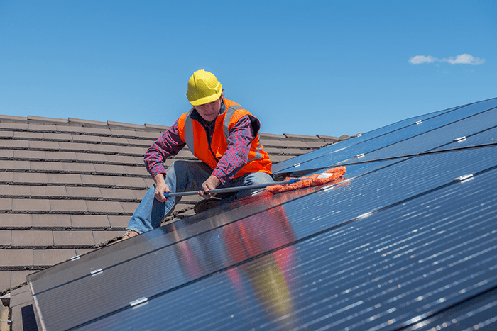 Worker installing solar panels on roof.