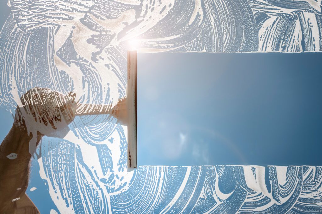 Image of a window getting cleaned with a squeegee by a professional window cleaning in Albuquerque